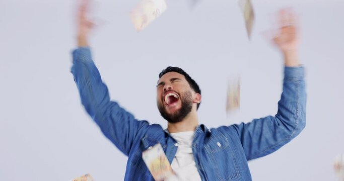 Winner, money rain and man with phone in studio for achievement, financial freedom and investment. Indian male celebrate on a grey background with smartphone betting, cash loan or bonus lottery prize