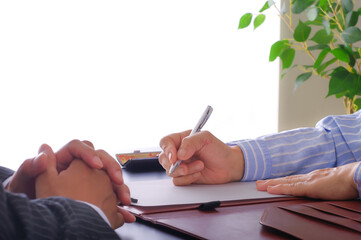 書類を記入する女性とそれを促す男性の手元