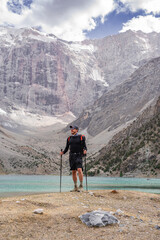 Man hiker exploring mountains lake in Tajikistan