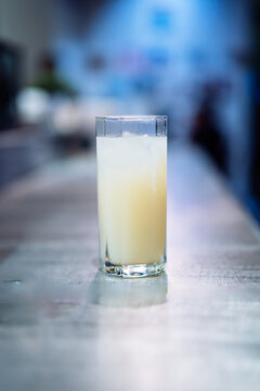 A glass of Ricard Yellow alcohol is on a bar