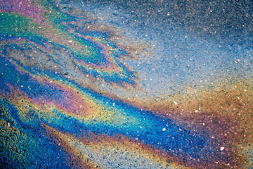 Texture of colorful petrol oil spill on wet pavement. Petrol Oil Pollution Rainbow Gasoline Leak on Pavement