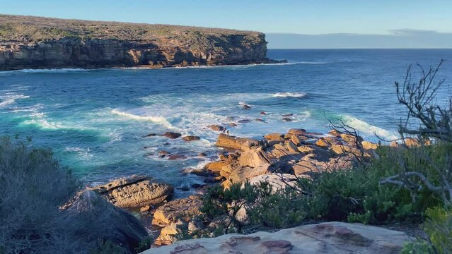 4k Video -Rock fishing and waves crashing in Royal National Park on the spectacular coastal walk at Wattamolla's Providential Point Lookout - South of Sydney, NSW, Australia.