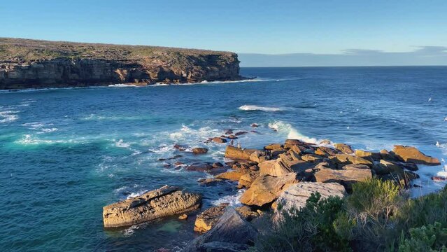 4k Video -Large waves crashing on the rocks in Royal National Park on the spectacular coastal walk at Wattamolla's Providential Point Lookout -South of Sydney, NSW, Australia.