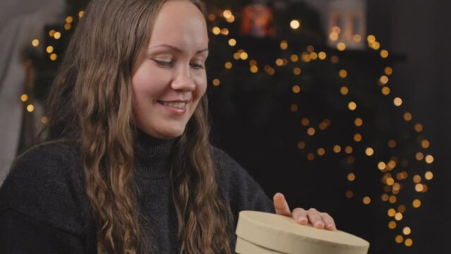 Excited woman opening christmas gift, with disappointment returns gift