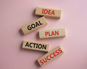 Idea Goal Plan Action Success symbol. Concept words Idea Goal Plan Action Success on wooden blocks. Beautiful pink background. Business concept. Copy space.