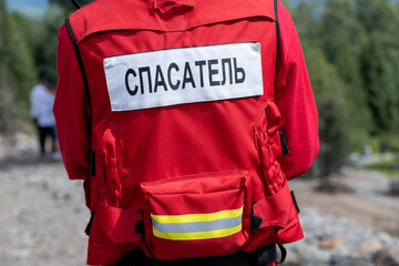 Rescuer in Russia in a uniform with the inscription on the back Rescuer. A man in a red jacket is ready to help in trouble and save lives.