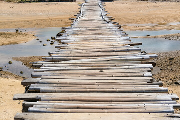 Fototapeta premium wooden bridge on the beach, wooden bridge over the river, wooden pier on the beach, temporary wooden bridge, wooden bridge at Seger Hill Beach-Lombok