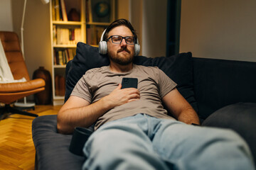 Fototapeta premium Caucasian man fell asleep while listening to relaxing music in the evening.