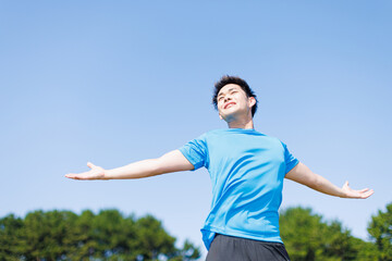 公園で新鮮な空気を楽しんでいる若いアジア人男性