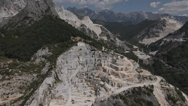 Pull back drone shot depicting the countless marble quarries of Carrara in Tuscany, Italy. The expensive white stone is known for its usage in renaissance art and architecture