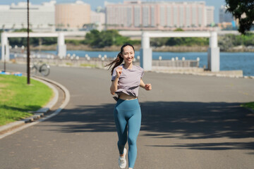 Fototapeta premium 屋外でジョギングする若いアジアの女性