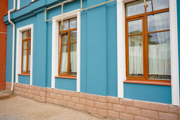 Blue wall of the house with a windows and details.