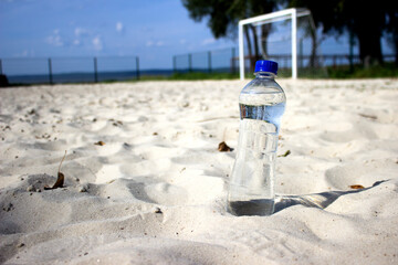 Plastic bottle of water on the beach. Conceptual image.