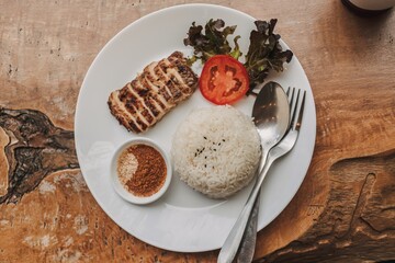 Baked chicken with white rice served on the table.