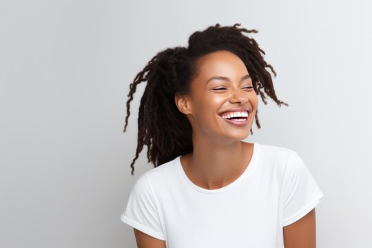 Closeup photo portrait of a beautiful young african american model woman smiling with clean teeth. Used for a dental ad. Isolated on light background.