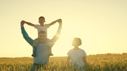 father mother child son happy family. happy family walking at sunset in wheat field. walk journey child boy on dad's shoulders. child surpergero dreams of flying. the dream of a little kid pilot