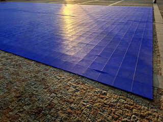 blue plastic tiles with a perforated surface serve as a flat surface for organizing outdoor dance...