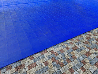 blue plastic tiles with a perforated surface serve as a flat surface for organizing outdoor dance...