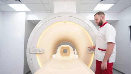 A doctor performs an MRI or PET scan of a patient in a modern clinic. Magnetic resonance imaging in...
