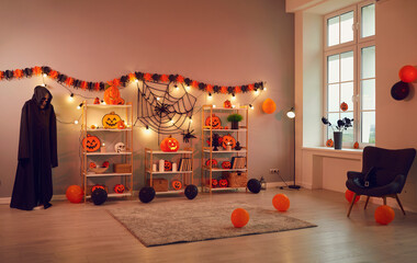 Interior of spacious room in house which is decorated with decorations in Halloween style. Room for Halloween party is decorated with pumpkins, lanterns, cobwebs, spiders, balloons and skeleton.