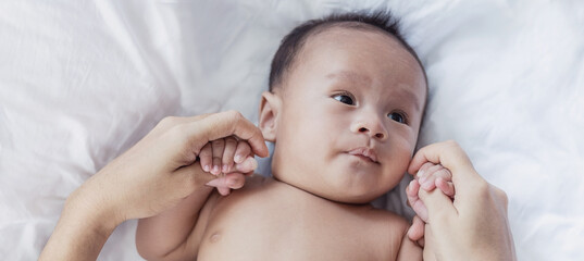 Portrait of asian parent hands holding newborn baby fingers, Closeup mother&rsquo;s hand holding their new born baby. Love family healthcare and medical body part nursery together happy mother&rsquo;s day concept