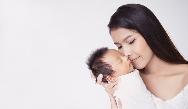 Closeup portrait of beautiful young asian mother day kissing her newborn baby. Healthcare and medical Indian hispanic family love lifestyle asia mother’s day parenthood concept panoramic banner