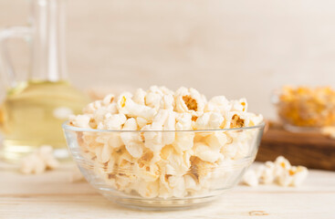 Prepared popcorn with ingredients on wooden table