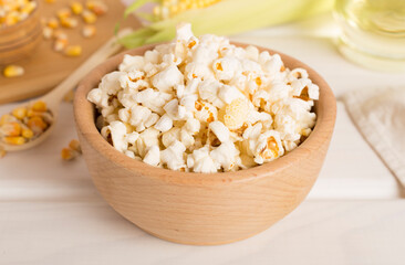 Prepared popcorn with ingredients on wooden table