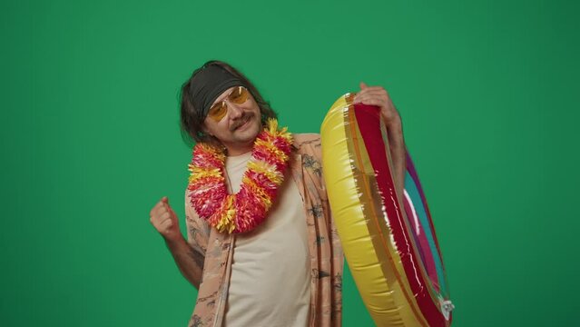 Happy man in casual clothing holds inflatable tube ring and doing little funny dance, smiling at the camera.