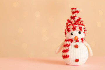 Cute snowman on table against blurred lights