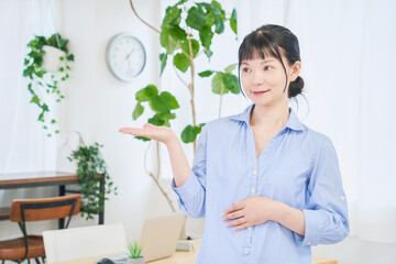 手で案内する自宅で仕事をする女性　立ちポーズ