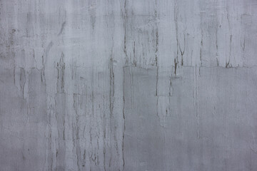 concrete outdoor wall with matte gray paint and black smudges - full-frame background and flat texture.