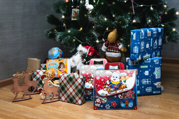 gifts in packaging and New Year's decor near the Christmas tree. Christmas holiday. family traditions