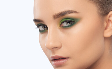 Brunette girl with beautiful green makeup, with clean skin, with round earrings. Makeup concept.