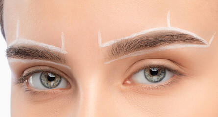 Make-up artist makes markings with white pencil for eyebrow and paints eyebrows. Professional...