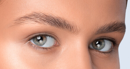 Fototapeta premium The make-up artist does Long-lasting styling of the eyebrows and will color the eyebrows. Eyebrow lamination. Professional make-up and face care.