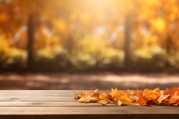 Naklejka na ściany i meble Beautiful colourful natural autumn background for presentation. Fallen dry orange leaves on wooden boards against the backdrop of a blurry autumn park