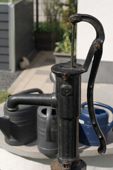 Various watering options with watering cans and hand water pump