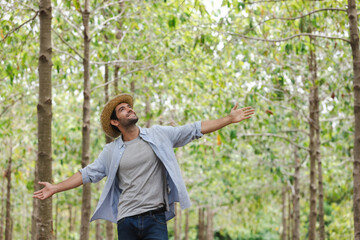 handsome man with beard in white shirt in a evergreen forest