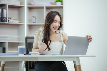 Young independent Asian woman working on laptop computer in modern office Perform accounting analysis, report real estate investment data. Financial concepts and tax system