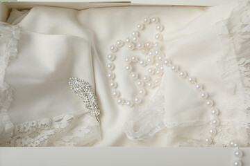 Wedding dress and jewelry on light background, top view