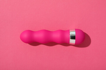 Pink silicone vibrator on a pink background.