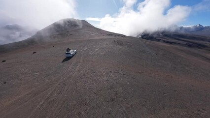Adventure footage of FPV drone chasing a Nissan Pathfinder with two people on the roof in the Bolivian Andes Mountains near the city of La Paz, Bolivia, South America.