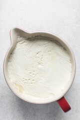 Greek yogurt in a white bowl, process of making Greek yogurt, strained yogurt in ceramic white bowl
