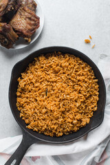 Jollof rice in a cast iron skillet, homemade party nigerian jollof rice in a skillet, overhead view of authentic homemade west african jollof rice