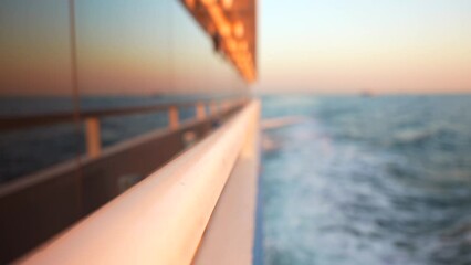 Blurred background with reflection of the sea in the floating yacht window at sunset