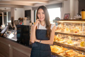 An Asian woman entrepreneur or barista working in modern coffee shop , concept small business