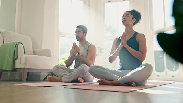 Couple, yoga fitness and praying with home meditation, zen exercise and mindfulness, healing or peace. People with namaste hands for calm energy, holistic training and spiritual workout or wellness