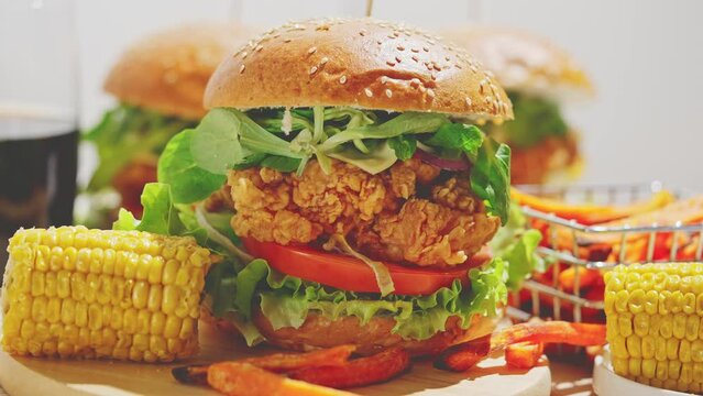 Fresh and tasty crispy chicken burger with melted cheese, lettuce, tomato, argula