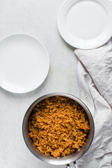 Jollof rice in a silver saucepan, homemade nigerian jollof rice in a pot, overhead view of authentic homemade west african jollof rice